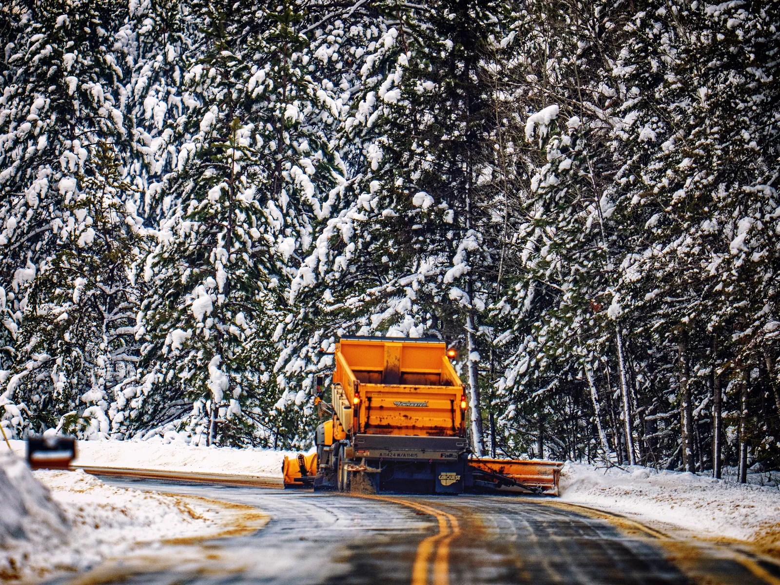 A snow plow clearing a roadway after a winter storm