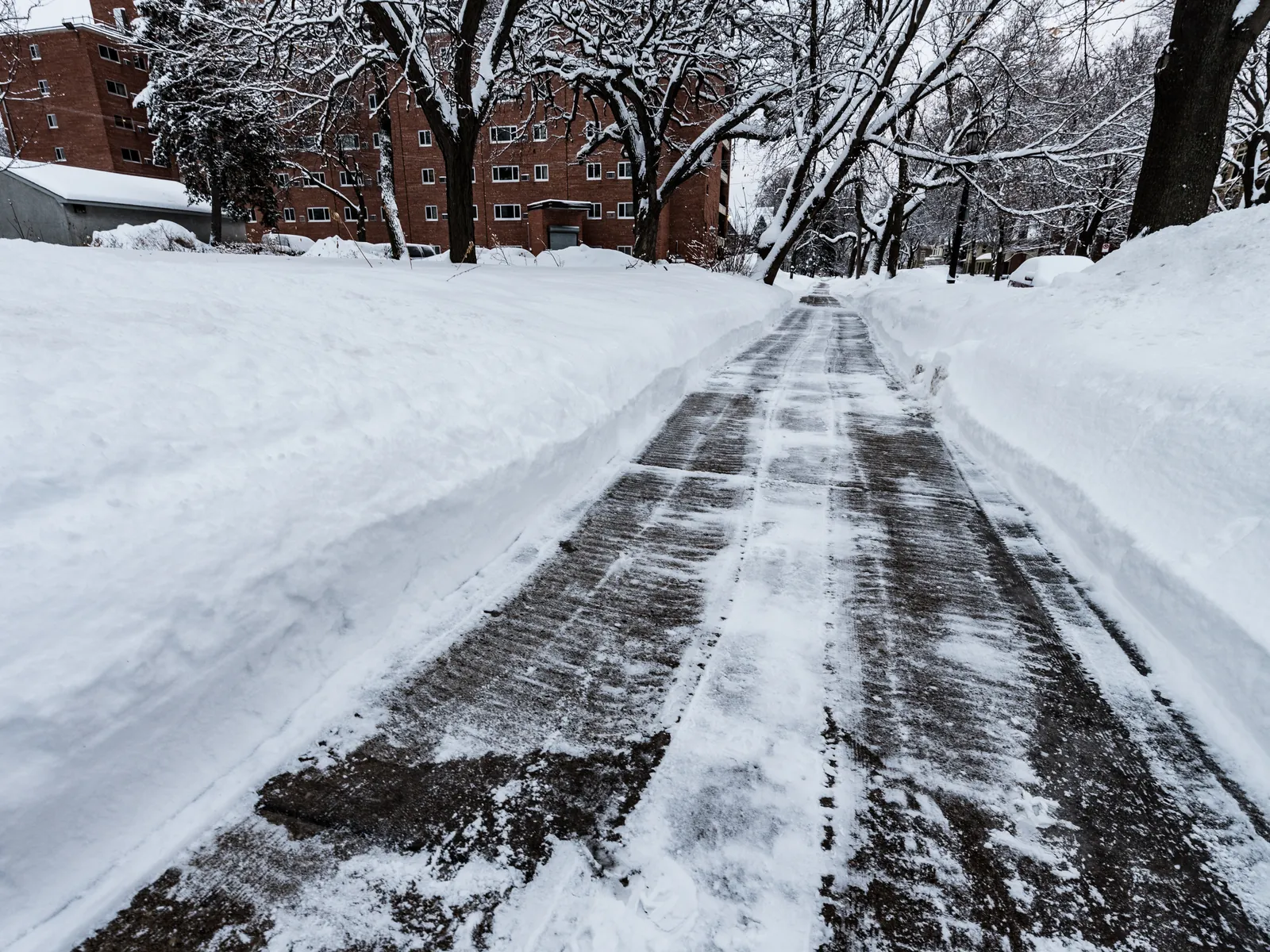A sidewalk professionally cleared through deep snow